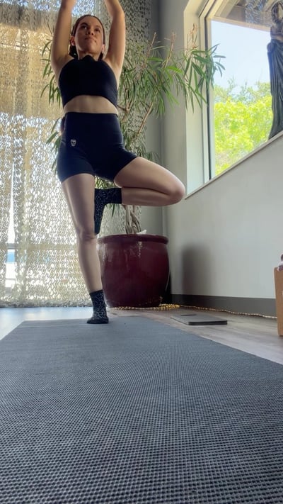 Flow Yoga Cedar Park student practicing yoga balance pose in bright studio, Austin Texas